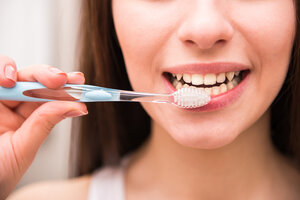 woman brushing teeth caring for dental veneers Gaithersburg, MD